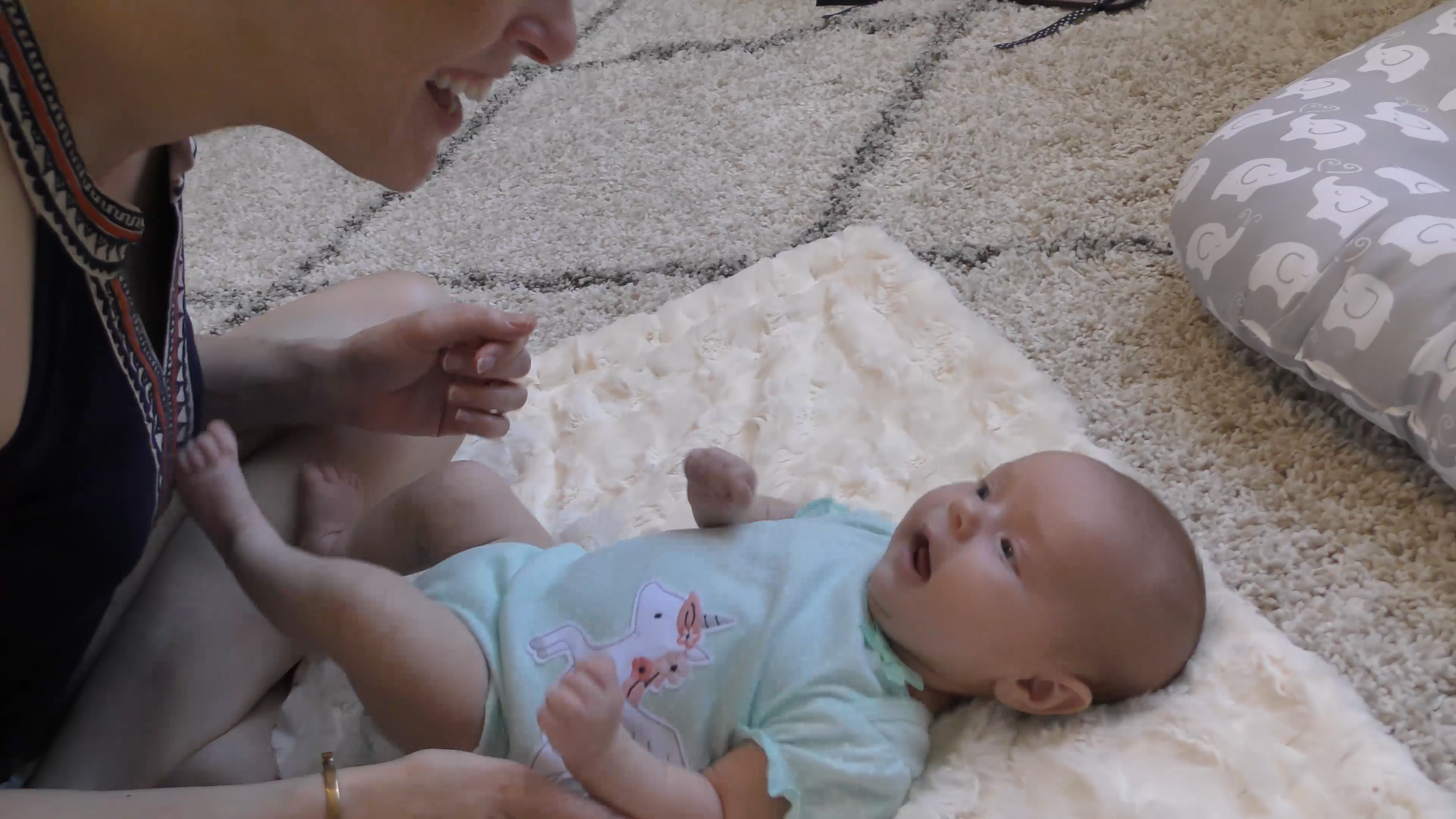 Mother playing with newborn baby girl, who is in the quiet alert state.
