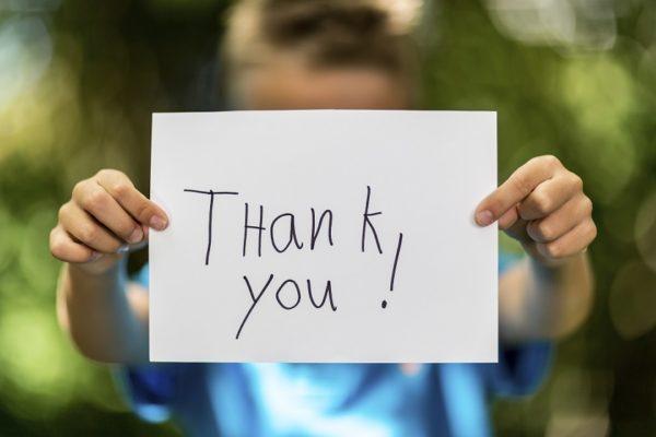 boy holding thank you sign aHPdmH