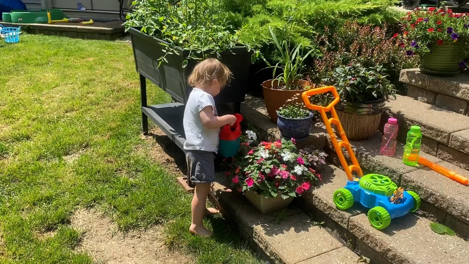 Preschool-age boy watering a flower pot during pretend play.
