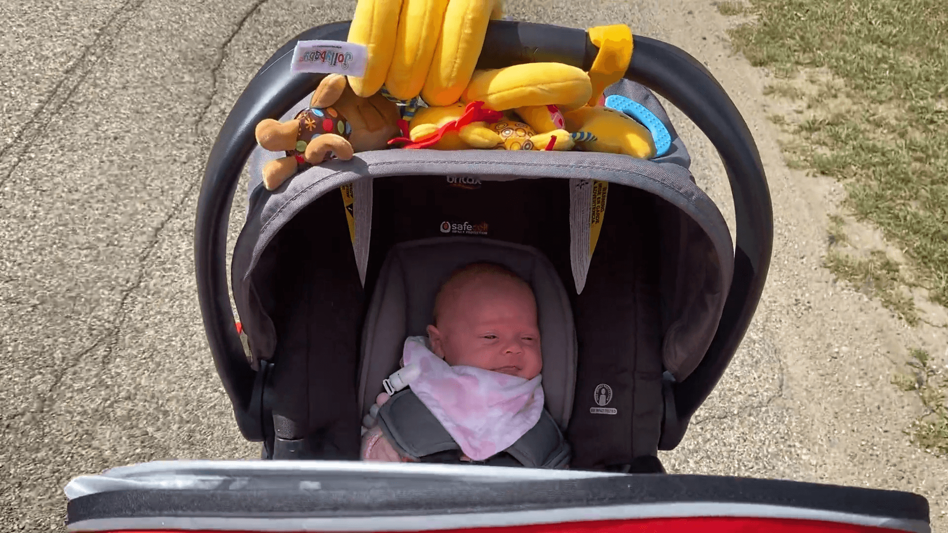 Baby sitting in a stroller with the sun cover pulled out.
