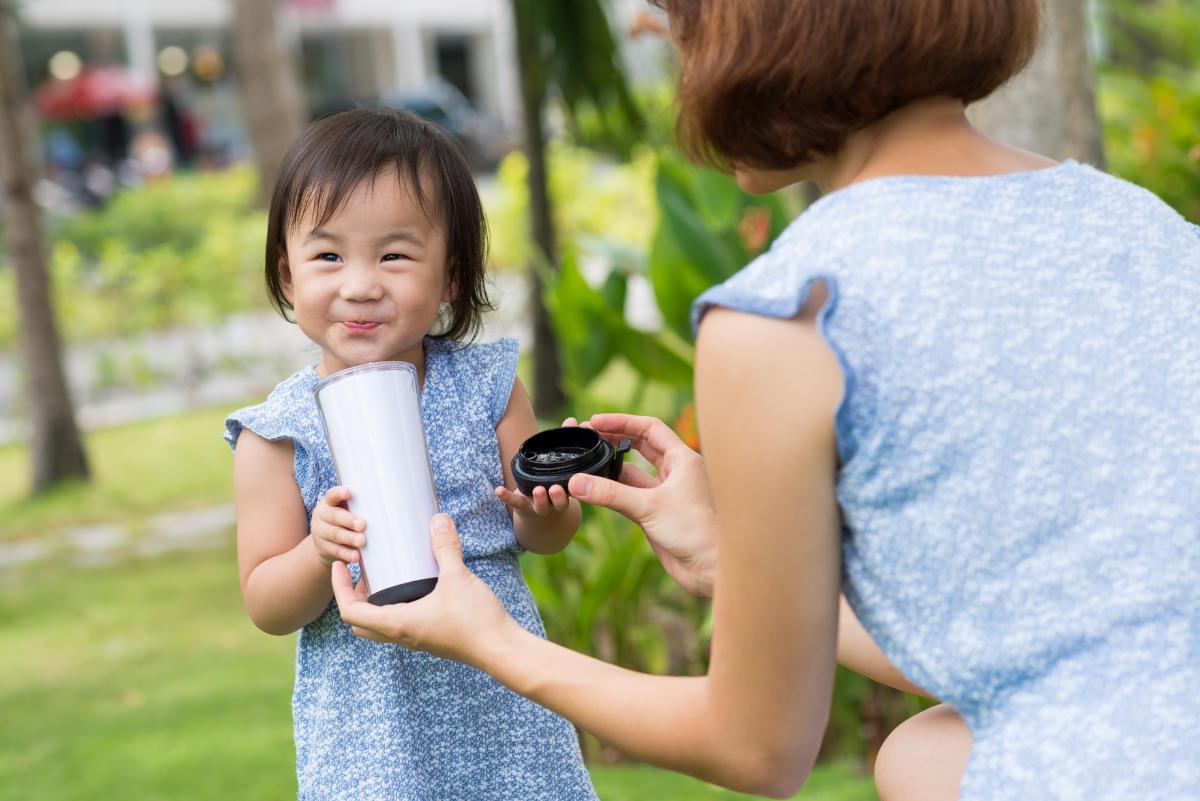 young girl drinking out of sippy cup