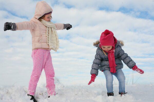 two_girls_walking_through_the_snow