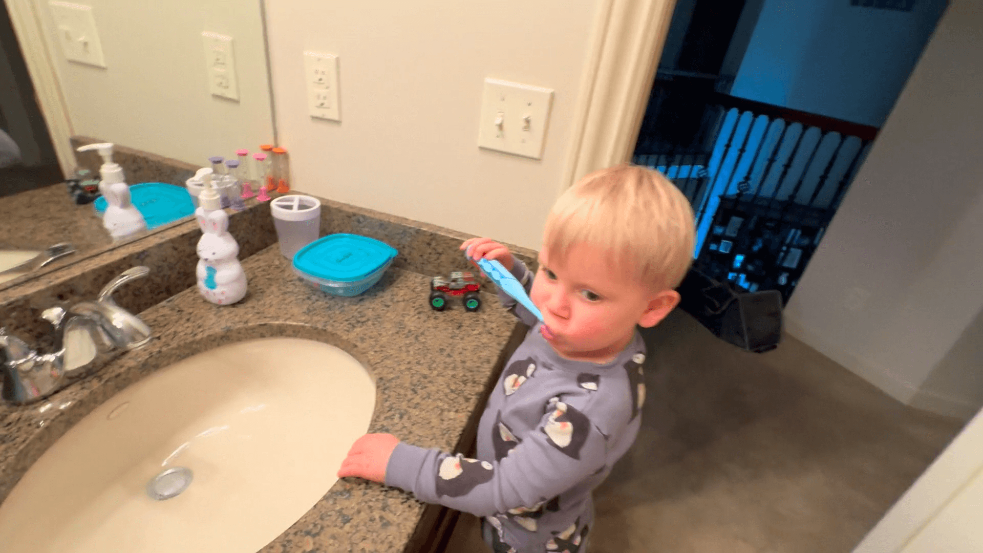 Toddler boy brushing his teeth in the bathroom as part of his bedtime routine.