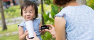 girl drinking from cup with mom outside