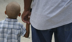 A young boy holding his dad's hand