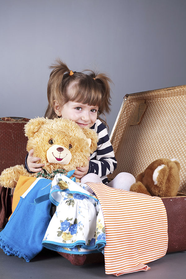 girl_sitting_in_suitcase_holding_teddy_bear_Small600px