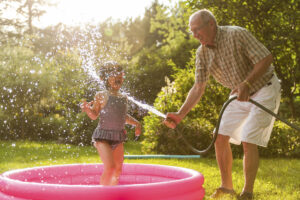 Water play with grandparent in outdoor kid's pool