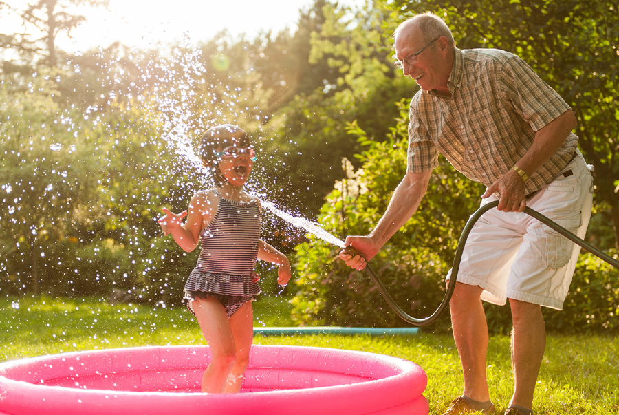 Water play with grandparent in outdoor kid's pool