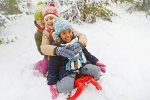 Kids sliding on snow in winter