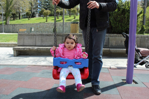 baby_girl_sititng_in_swing_dad_pushing