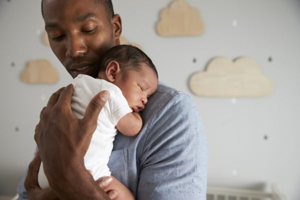 dad holding and cuddling newborn baby