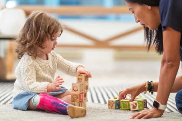 Little-girl-with-prosthetic-leg-at-therapy-appointment