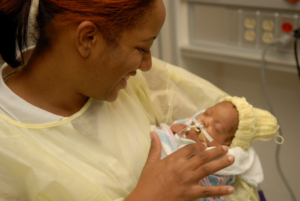 Mom holding baby for Baby Massage in NICU