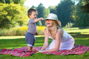 mom_and_son_on_grass_playing_with_hat