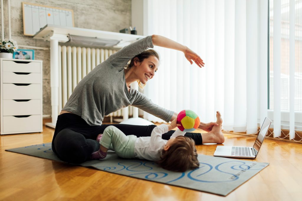 Mother Exercise With Her Baby At Home