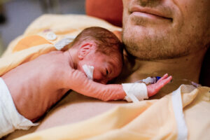 premature baby lies on dad's chest